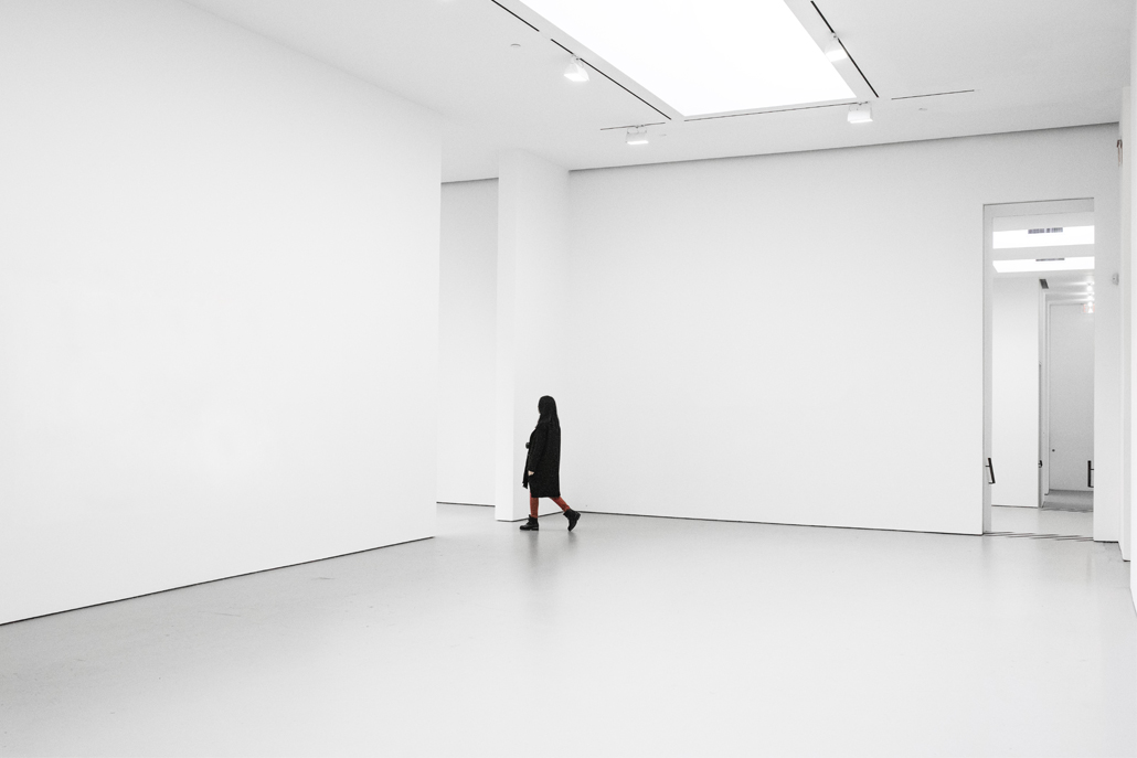 ﻿Woman walking from one all white room to the next